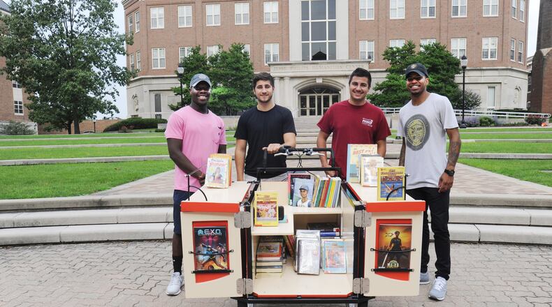 The Words on Wheels program will introduce a new bicycle designed to carry 300-400 books to give out at the Springfield High football game on Sept. 8. Pictured from left are Moses Mbeseha, The Conscious Connect co-founder), University of Dayton students Matt Forsthoefel and Gunar Stover and Karlos L. Marshall, also a co-founder of The Conscious Connect. Contributed photo