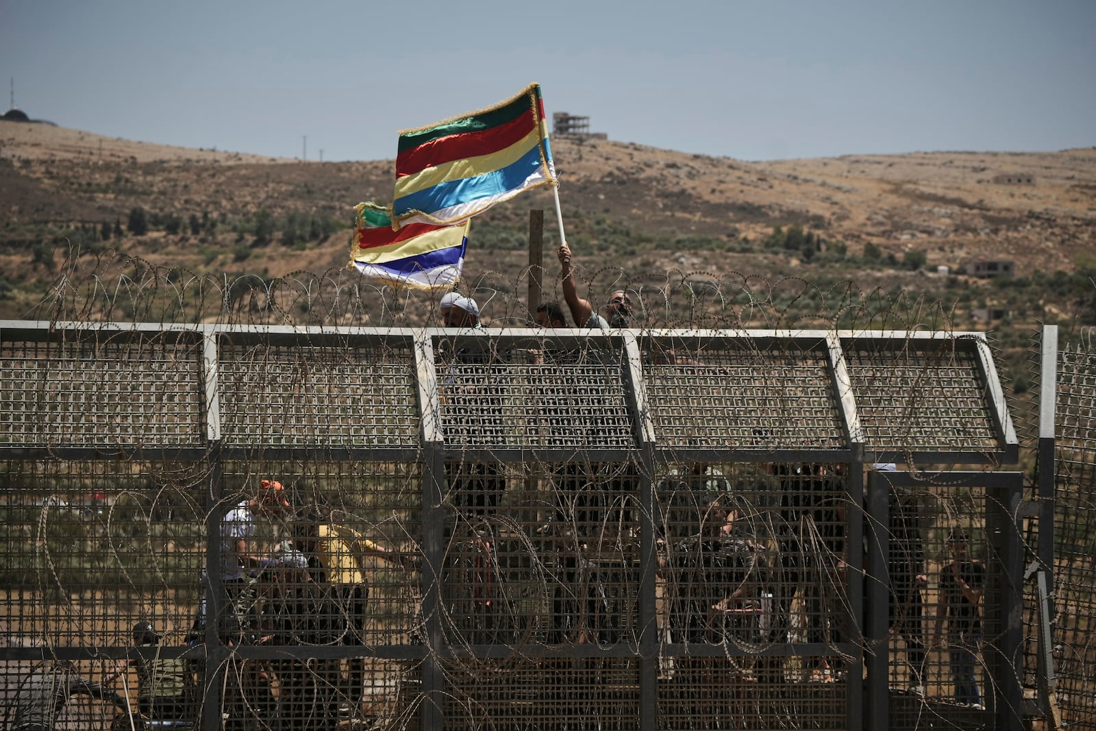 Syrian Druze protest near the Israeli-Syrian border, as seen from the town of Majdal Shams in the Israeli-controlled Golan Heights, Wednesday, July 16, 2025, amid the ongoing clashes between Syrian government forces and Druze armed groups in the southern Syrian city of Sweida. (AP Photo/Leo Correa)