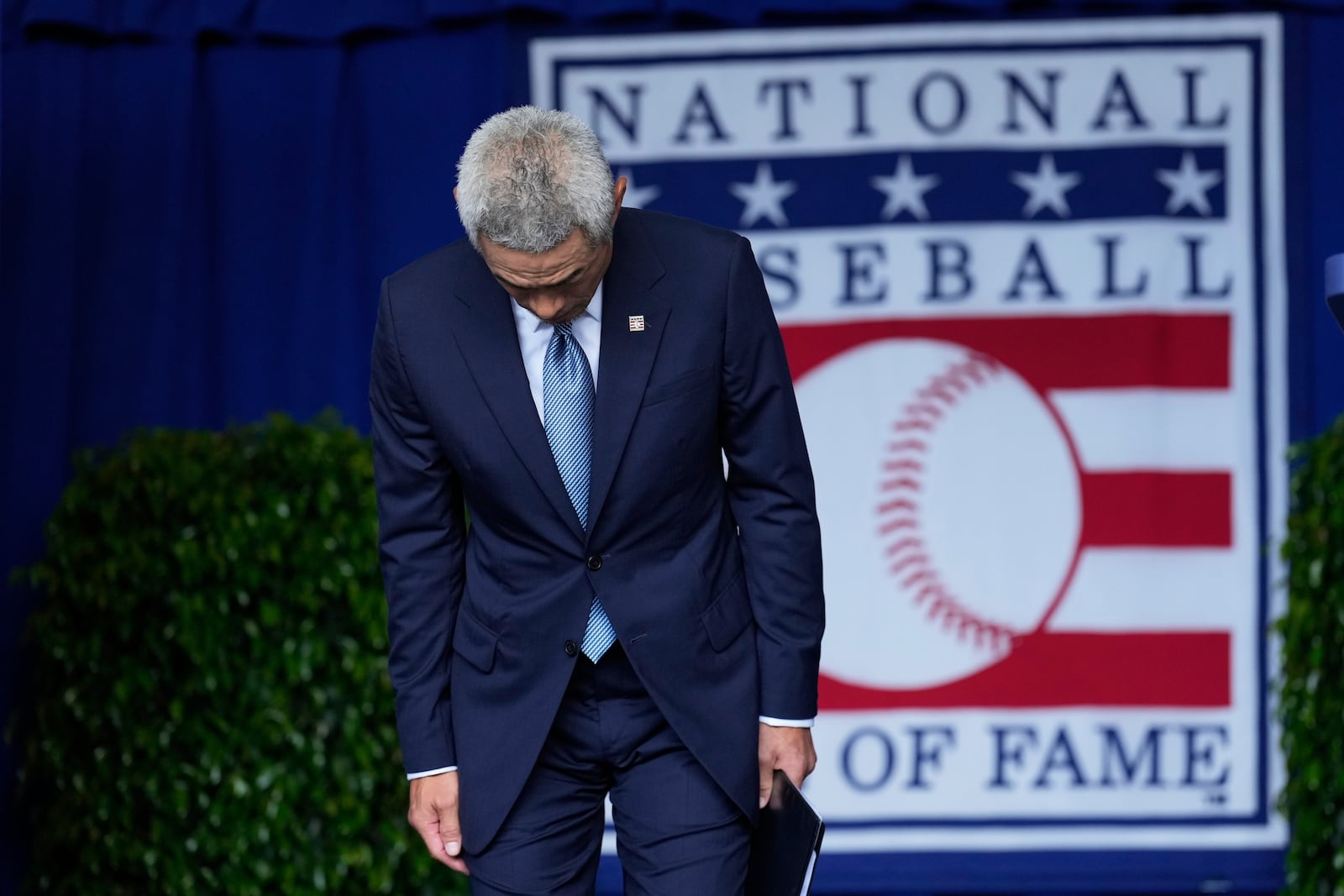 Baseball Hall of Fame inductee Ichiro Suzuki bows as he arrives on stage during the National Baseball Hall of Fame induction ceremony in Cooperstown, N.Y., Sunday, July 27, 2025. (AP Photo/Seth Wenig)