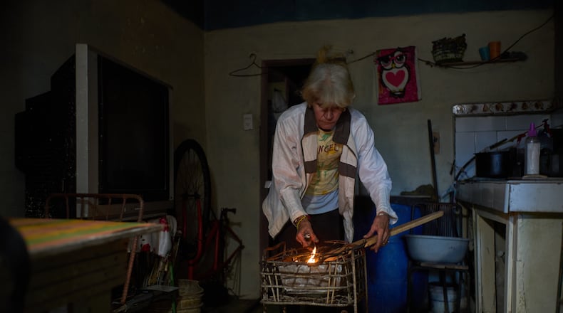 Minorkys Hoyos Ruiz lights coals to cook dinner during a scheduled blackout to ration energy in Santa Cruz del Norte, home to one of Cuba’s largest thermoelectric plants, late afternoon Tuesday, Feb. 3, 2026. (AP Photo/Ramon Espinosa)