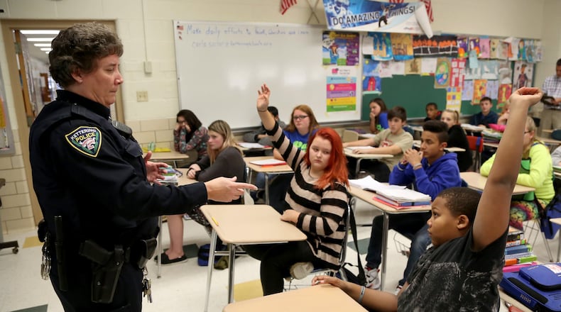 Kettering Police school resource officer Carla Sucher talks with seventh-grade students in a health class at Van Buren Middle School about alcohol abuse. Many schools rely on the presence of SROs to boost security. LISA POWELL / STAFF