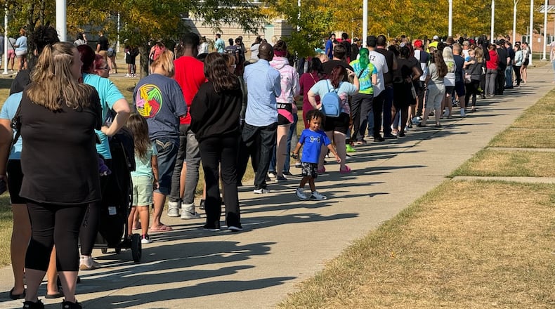 Parents wait in line at Springfield High School to pick up Simon Kenton Elementary students Monday. BILL LACKEY/STAFF
