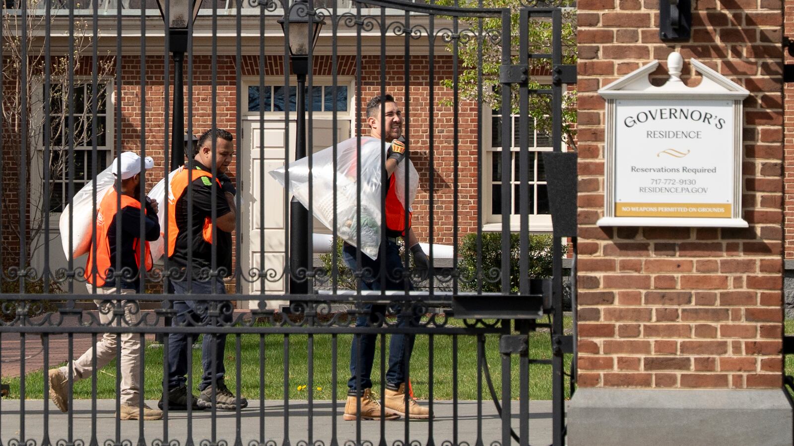 Workers trash items following an arson attack on Pennsylvania governor's official residence in Harrisburg, Pa., Tuesday, April 15, 2025. (AP Photo/Mingson Lau)