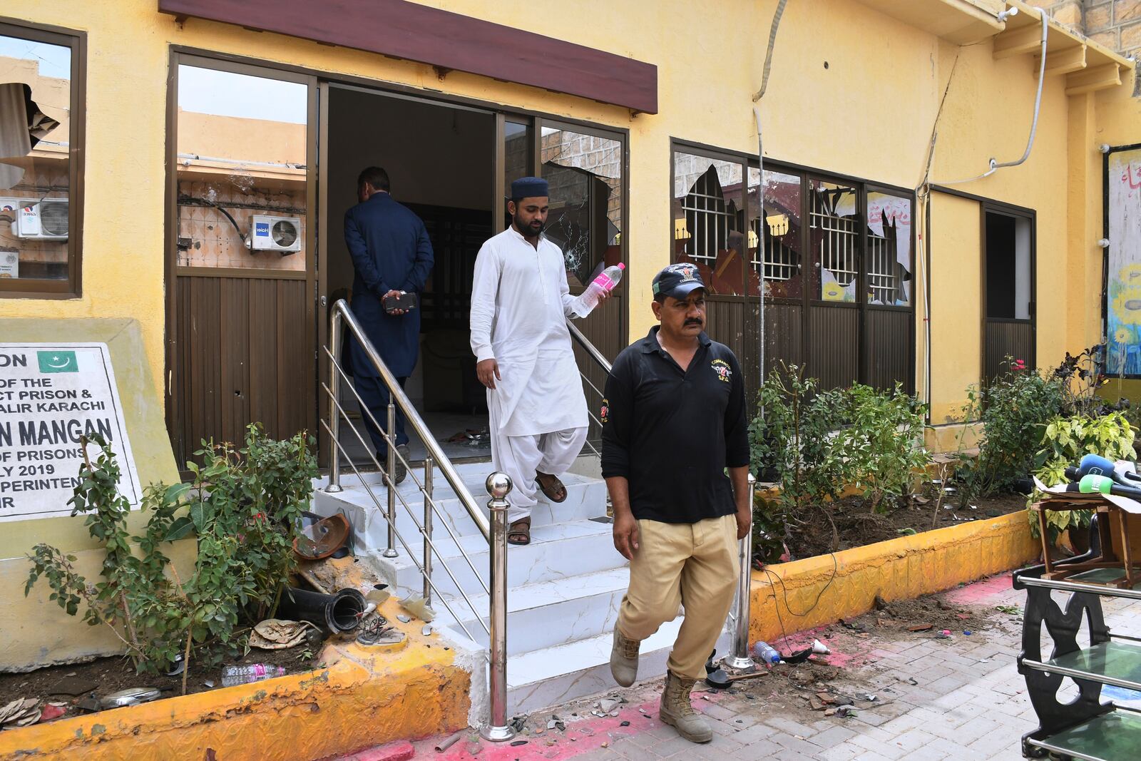 Police officers examine a damaged area inside the premises of the district Malir prison from where more than 100 inmates escaped overnight, in Karachi, Pakistan, Tuesday, June 3, 2025. (AP Photo/Ali Raza)