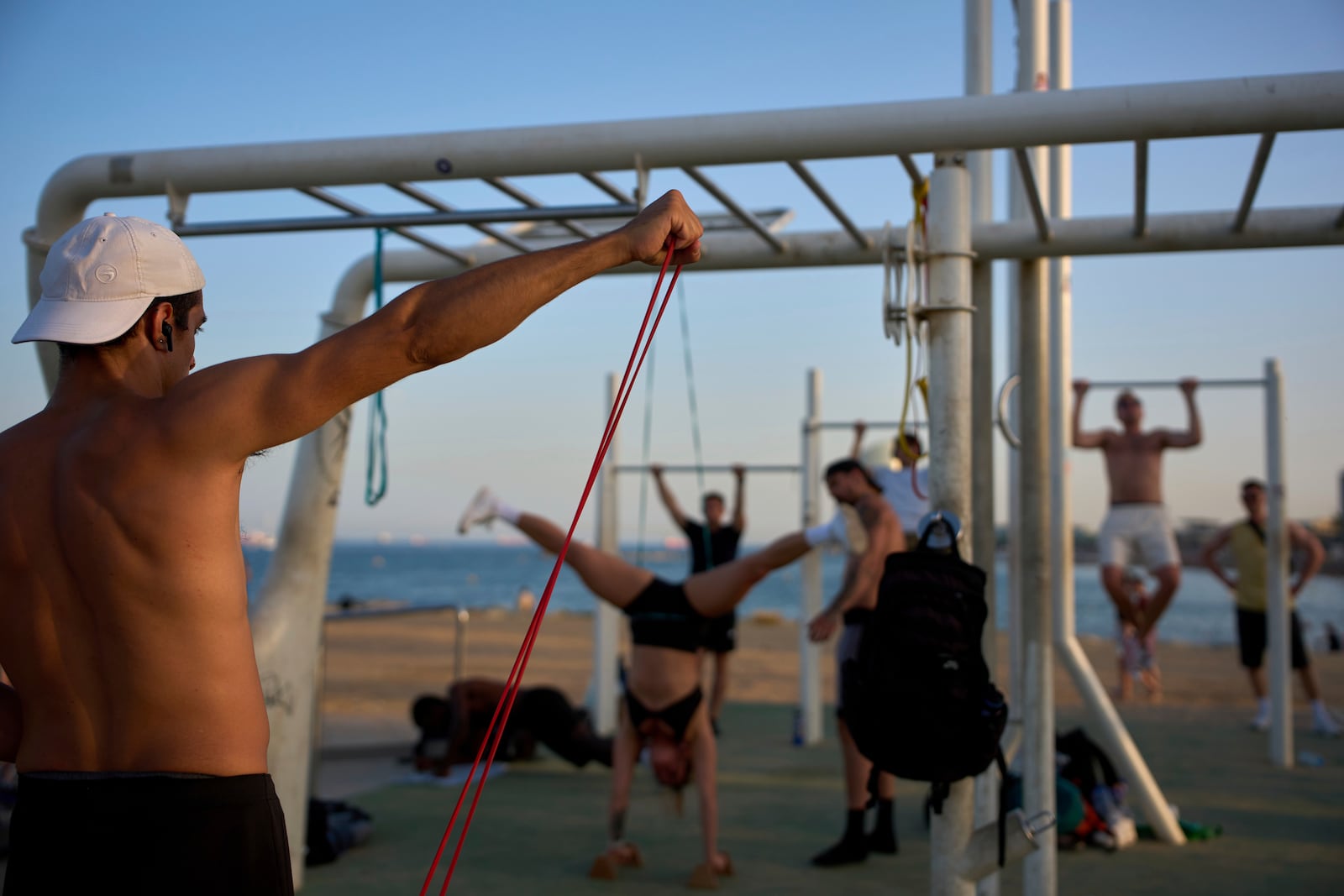 People work out in an open-air gym next to the beach in Barcelona, Spain, Tuesday, June 25, 2025. (AP Photo/Emilio Morenatti)