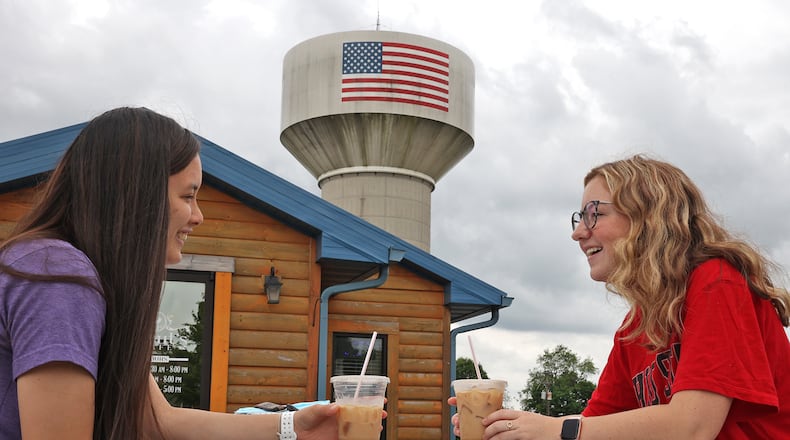 The Northridge Water Tank looms over Emma Randall, left, and Cassie Pencil as they enjoy their cold beverages outside Scouts Cafe. BILL LACKEY/STAFF