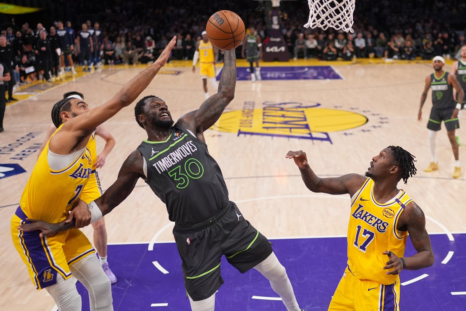 Minnesota Timberwolves forward Julius Randle, center, grabs a rebound away from Los Angeles Lakers guard Gabe Vincent, left, and forward Dorian Finney-Smith during the first half in Game 5 of an NBA basketball first-round playoff series Wednesday, April 30, 2025, in Los Angeles. (AP Photo/Mark J. Terrill)