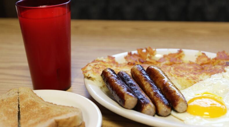 Breakfast food served at the Olympic Family Style is shown with orange juice. The breakfast includes sausage, eggs and hash browns with toast. Parker Perry/Staff