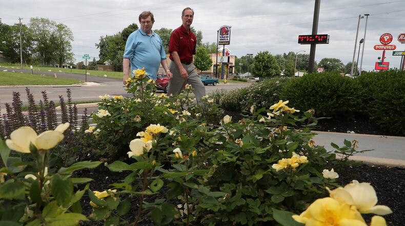 Springifeld City Commissioner David Estrop and City Manager Jim Bodenmiller walk past the flowers planted in front of the McDonald’s restaurant on South Limestone Wednesday, May 30, 2018. The city was recognizing businesses that kept their properties clean and beautiful. Bill Lackey/Staff