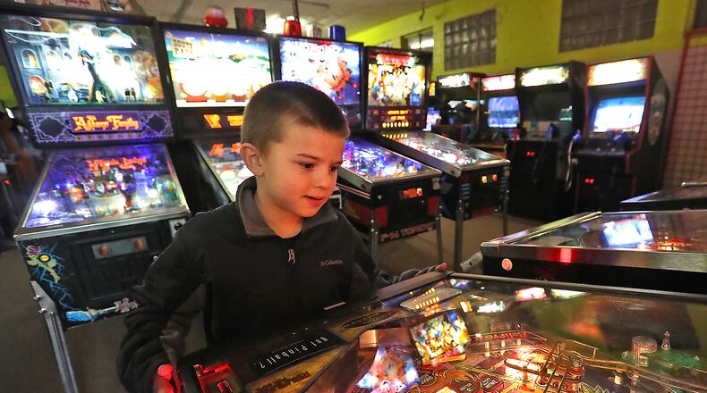 Jayden Edwards, 8, plays a pinball game in the gameroom at Game Cycle. Bill Lackey/Staff