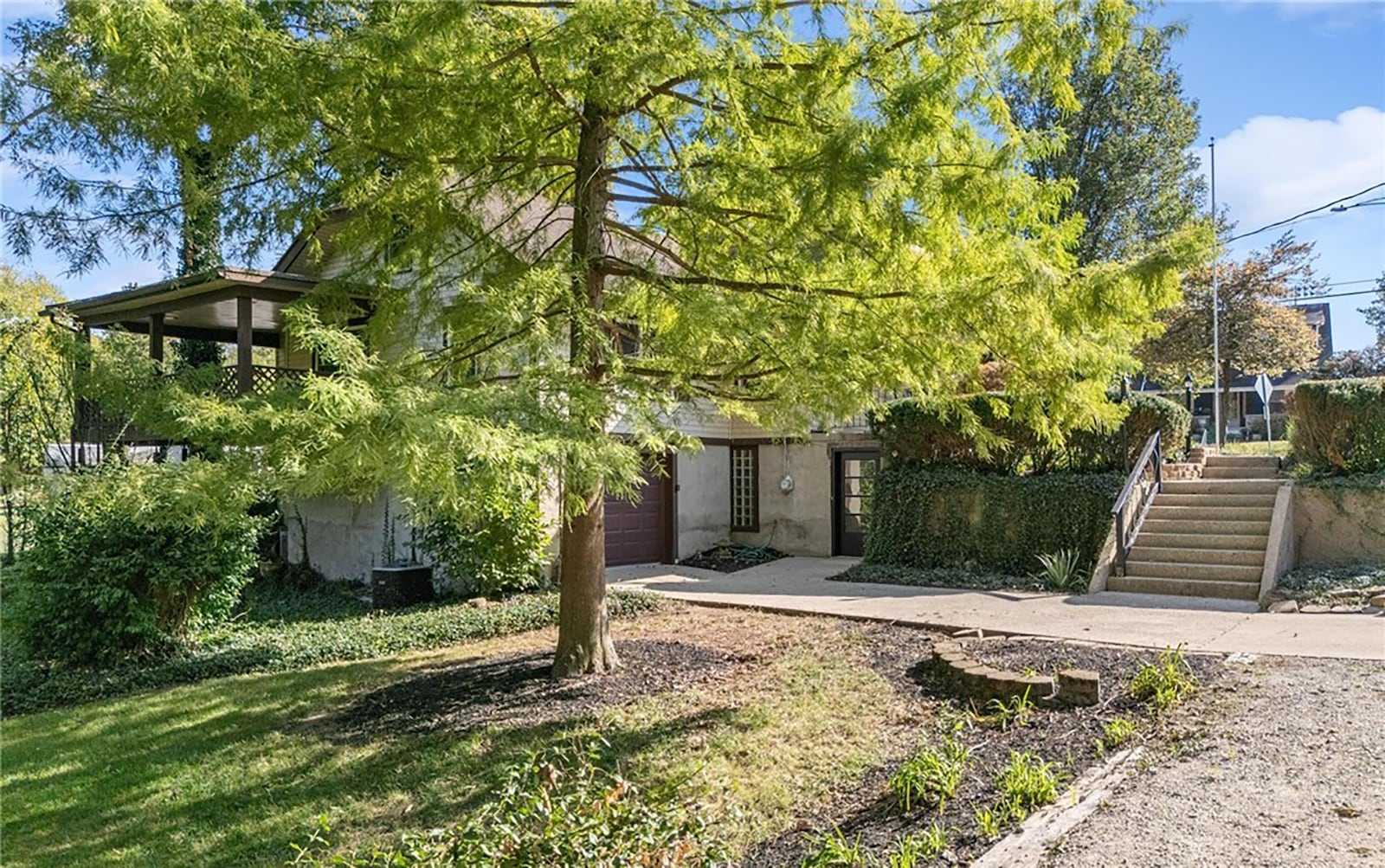 The two car tandem garage is on the basement level and there is an exterior door that walks into the finished part of the basement. Steps lead to a walkway and the covered front porch. CONTRIBUTED