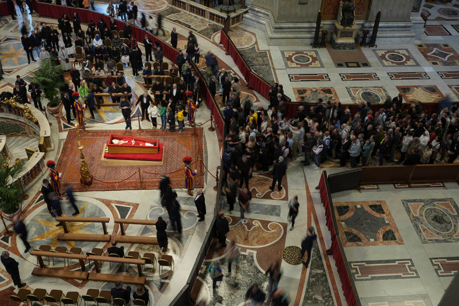 Faithful pay their respects to Pope Francis lying in state inside St. Peter's Basilica at the Vatican, Thursday, April 24, 2025. (AP Photo/Alessandra Tarantino)