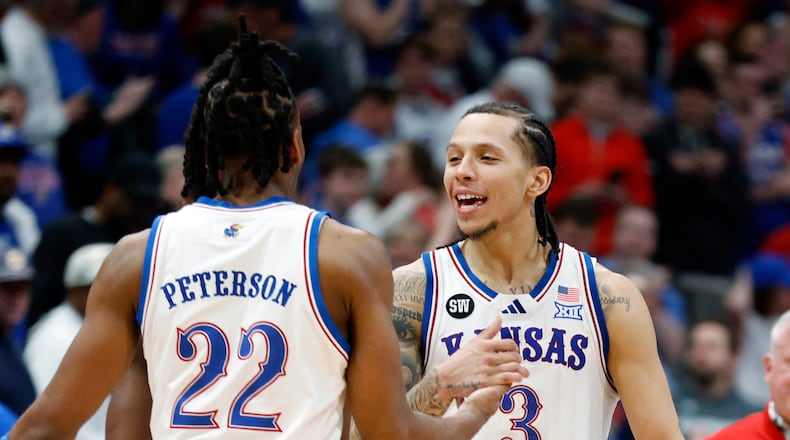 Kansas guards Tre White (3) and Darryn Peterson (22) celebrate after an NCAA college basketball game against Houston, Monday, Feb. 23, 2026, in Lawrence, Kan. (AP Photo/Colin E. Braley)
