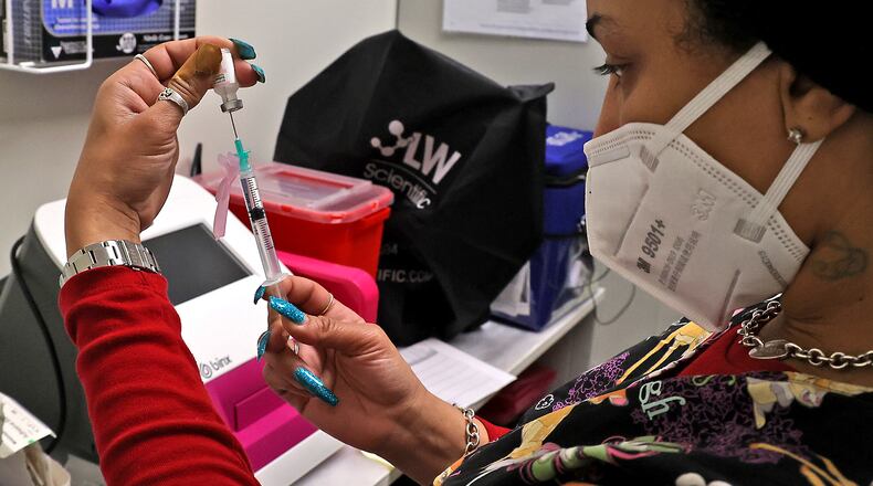 Senika Channels gets a patient's COVID vaccine ready at the Clark County Combined Health District office in the Southern Village Shopping Center. BILL LACKEY/STAFF