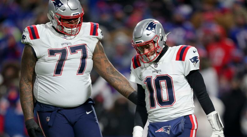 New England Patriots quarterback Mac Jones (10) reacts alongside offensive tackle Trent Brown (77) during the second half of an NFL wild-card playoff football game against the Buffalo Bills, Saturday, Jan. 15, 2022, in Orchard Park, N.Y. (AP Photo/Joshua Bessex)