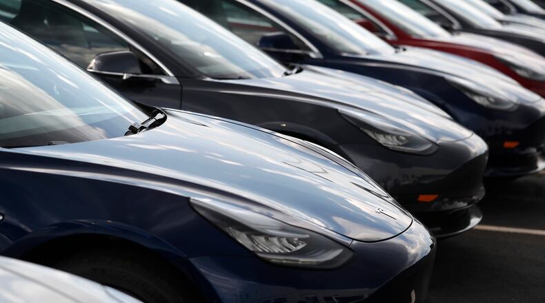 FILE - Several 2018 Model 3 sedans sit on display outside a Tesla showroom, July 8, 2018, in Littleton, Colo. (AP Photo/David Zalubowski, File)