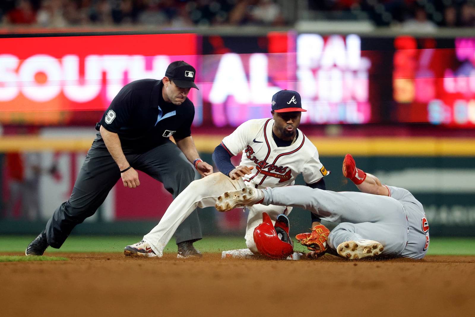 Atlanta Braves second baseman Ozzie Albies (1) tags out Cincinnati Reds' Blake Dunn (59) as he tries to steal second base during the eleventh inning of a baseball game, Thursday, May 8, 2025, in Atlanta. (AP Photo/Butch Dill)