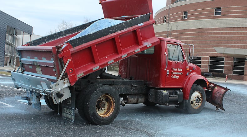 Clark State Community College employee, Amanda Honeycutt spreads salt around the Kuss Auditorium parking lot in anticipation of the ice storm. JEFF GUERINI/STAFF