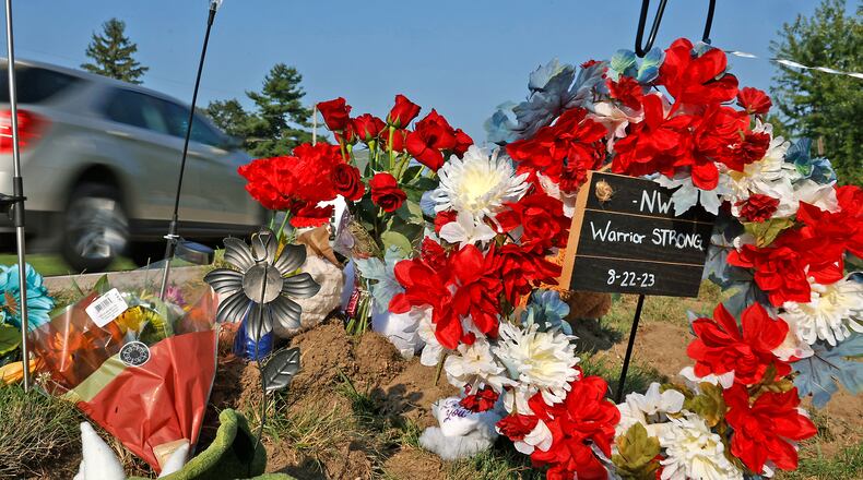 A memorial has started to form Wednesday, August 23, 2023 along Troy Road at the site of Tuesday's fatal bus crash. BILL LACKEY/STAFF