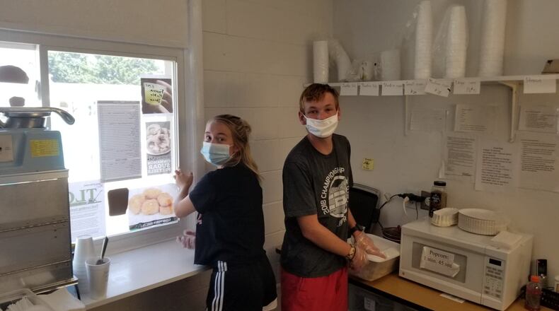 Tia Runner and Dylan Bledsoe work in concession stand at New Carlisle Pool. Photo by Mike Lowrey