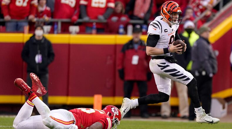 Cincinnati Bengals quarterback Joe Burrow (9) runs from Kansas City Chiefs defensive end Chris Jones, left, during the second half of the AFC championship NFL football game, Sunday, Jan. 30, 2022, in Kansas City, Mo. (AP Photo/Charlie Riedel)