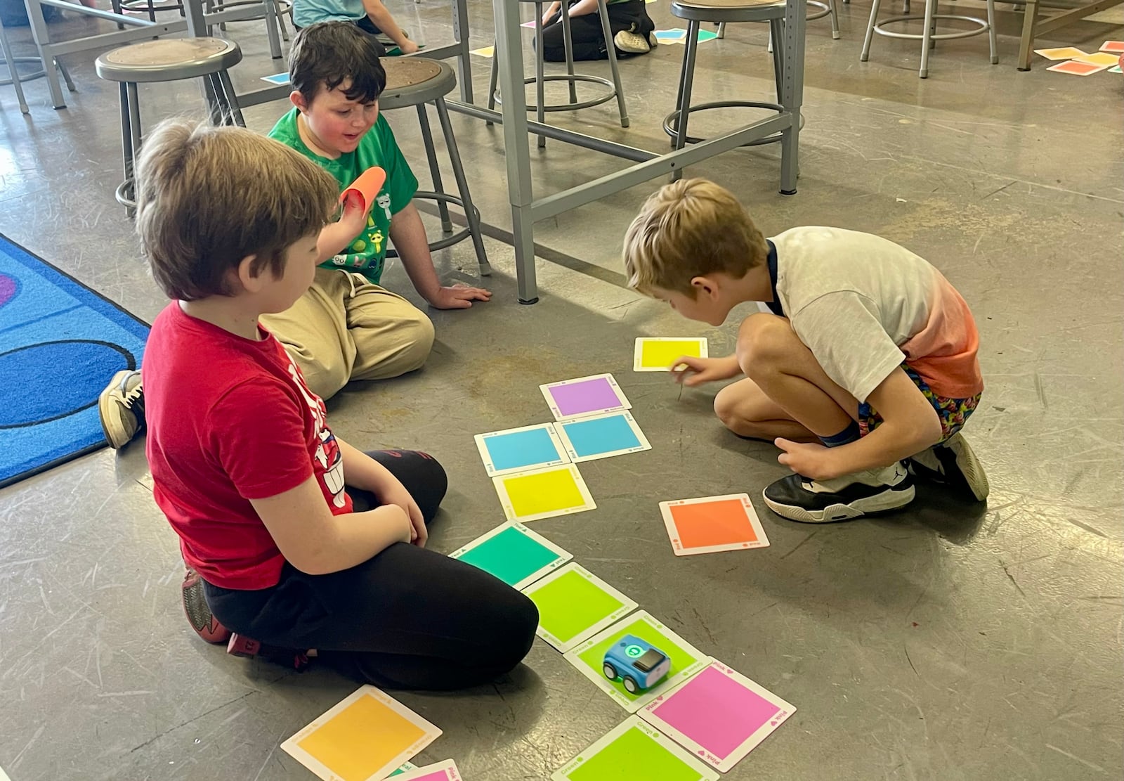 Second graders at Shawnee Elementary School decipher the colored tiles in their introduction to coding activity. Students used colored tiles to "program" their cars to follow the correct sequence. CLARK-SHAWNEE LOCAL SCHOOLS / CONTRIBUTED
