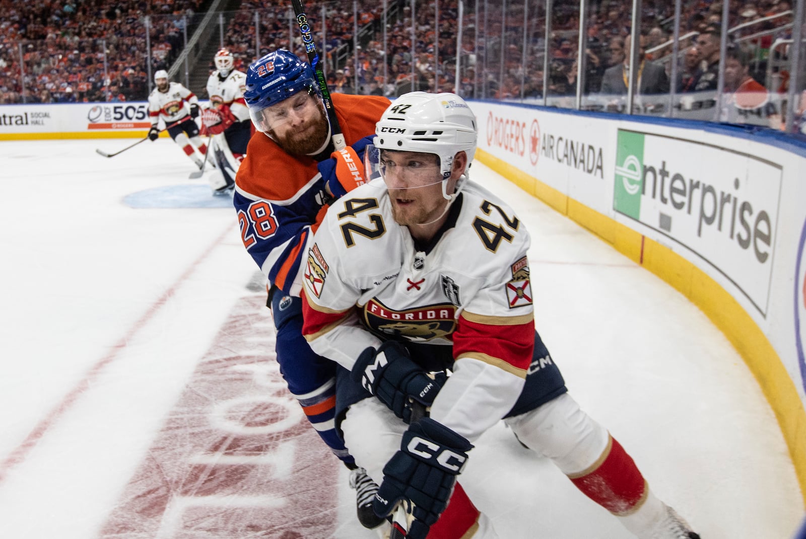 Florida Panthers' Gustav Forsling (42) battles for the puck with Edmonton Oilers' Connor Brown (28) during the second period in Game 1 of the NHL hockey Stanley Cup final series in Edmonton, Alberta, Wednesday, June 4, 2025. (Jason Franson/The Canadian Press via AP)