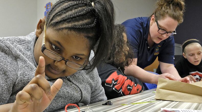 Jadie Welliford, a fourth grader, plays with the electric motor she made as Dr. Amanda King helps another student during one of the breakout sessions at the Springfield City Schools’ STEM program for girls Monday evening. Bill Lackey/Staff