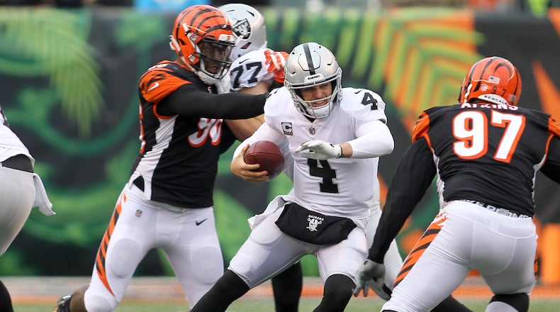 CINCINNATI, OH - DECEMBER 16: Derek Carr #4 of the Oakland Raiders attempts to run the ball past Geno Atkins #97 of the Cincinnati Bengals during the fourth quarter at Paul Brown Stadium on December 16, 2018 in Cincinnati, Ohio. Oakland defeated Cincinnati 30-16. (Photo by John Grieshop/Getty Images)
