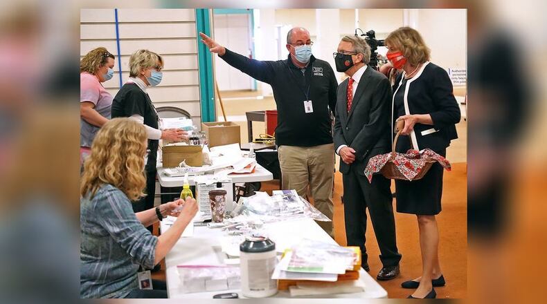 Clark County Health Commissioner Charles Patterson gives Governor Mike DeWine and his wife, Fran, a tour of the Clark County COVID vaccine distribution center at the Upper Valley Mall in 2021. BILL LACKEY/STAFF