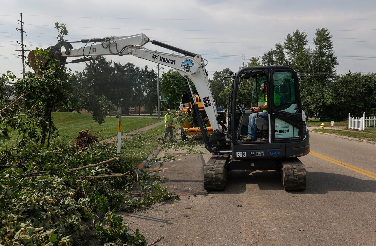 David Beard, of the Clark County Engineer Road Department, uses a truck to remove branches and leaves from the ground on Monday, July 21, 2025, following a storm that happened over the weekend in Moorefield Township. JOSEPH COOKE/STAFF