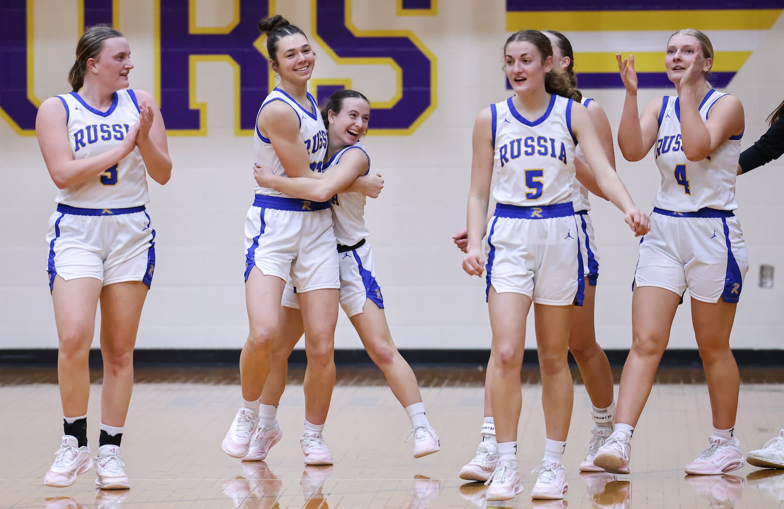 Russia senior guard Kourtney Phlipot (center right) hugs senior center Kora Doseck after the Raiders beat Cedarville 40-32 in a Division VII regional final on Saturday, March 7 at Vandalia-Butler's Student Activity Center. BRYANT BILLING / STAFF