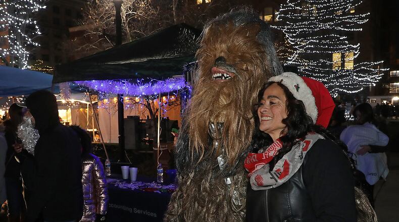 Alyce Comer gets her picture taken with Chewbacca from Star Wars at the LWS Tax and Accounting Kettle Wars booth at Holiday in the City Saturday. BILL LACKEY/STAFF