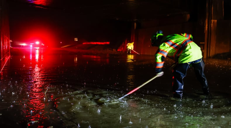 Dustin Carpenter from Ohio Department of Transportation works to clear drains on a flooded Germantown Road early Thursday morning, March 5, 2026 in Madison Township in Butler County. Heavy rain caused flooding in many areas. NICK GRAHAM/STAFF