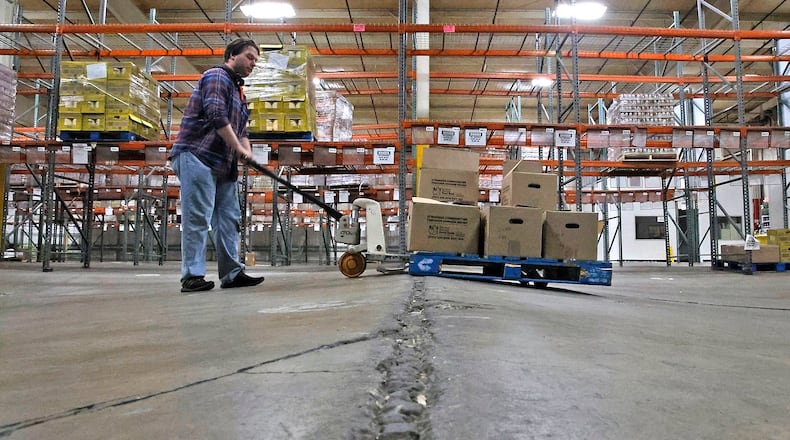 Ben Anderson pumps up the pallet jack to make it over a hump in the floor at the Second Harvest Food Bank's warehouse Wednesday, March 6, 2024. BILL LACKEY/STAFF
