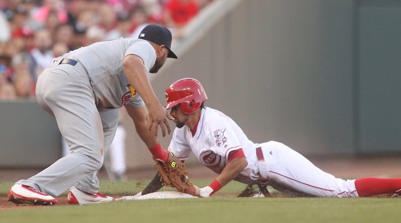 The Reds’ Billy Hamilton slides into third base ahead of a tag by the Cardinals’ Jhonny Peralta on Wednesday, June 8, 2016, at Great American Ball Park in Cincinnati. David Jablonski/Staff