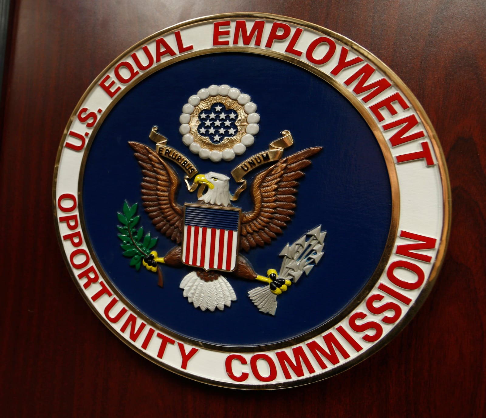FILE - The emblem of the U.S. Equal Employment Opportunity Commission (EEOC) is shown on a podium in Vail, Colo., Feb. 16, 2016. (AP Photo/David Zalubowski, File)