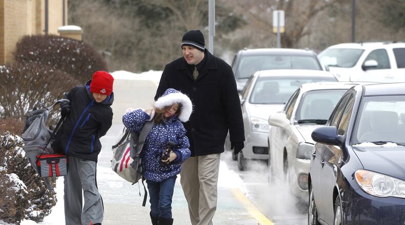 Dan Hake, principal at Concord Elementary School in Troy, escorts students into school Wednesday after they were dropped off for a late start because of the weather. Troy City Schools have called off classes seven days so far this year. Majority of area schools reach maximum calamity days | Table: How does your district stack up against the rest?