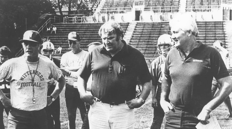 Wittenberg head coach Dave Maurer, left, and CBS announcers John Madden and Pat Summerall talk during practice the week of Wittenberg’s nationally-televised game against Baldwin-Wallace in Springfield in 1982. File photo