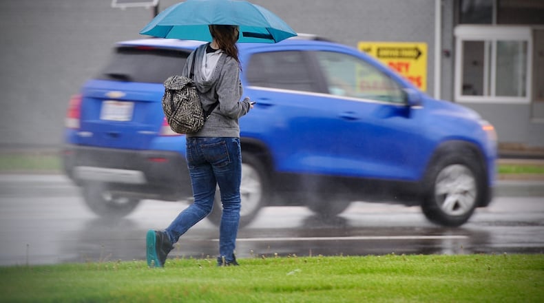 FILE PHOTO It's a good day to have a umbrella if you're out and about. Here is a person walking on N. Dixie Dr. Thursday April 29, 2021.