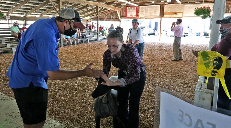 Abigail Getz is congratulated by the father, Rodney, after winning her division during the sheep showmanship competion at the Clark County Fair Saturday. BILL LACKEY/STAFF