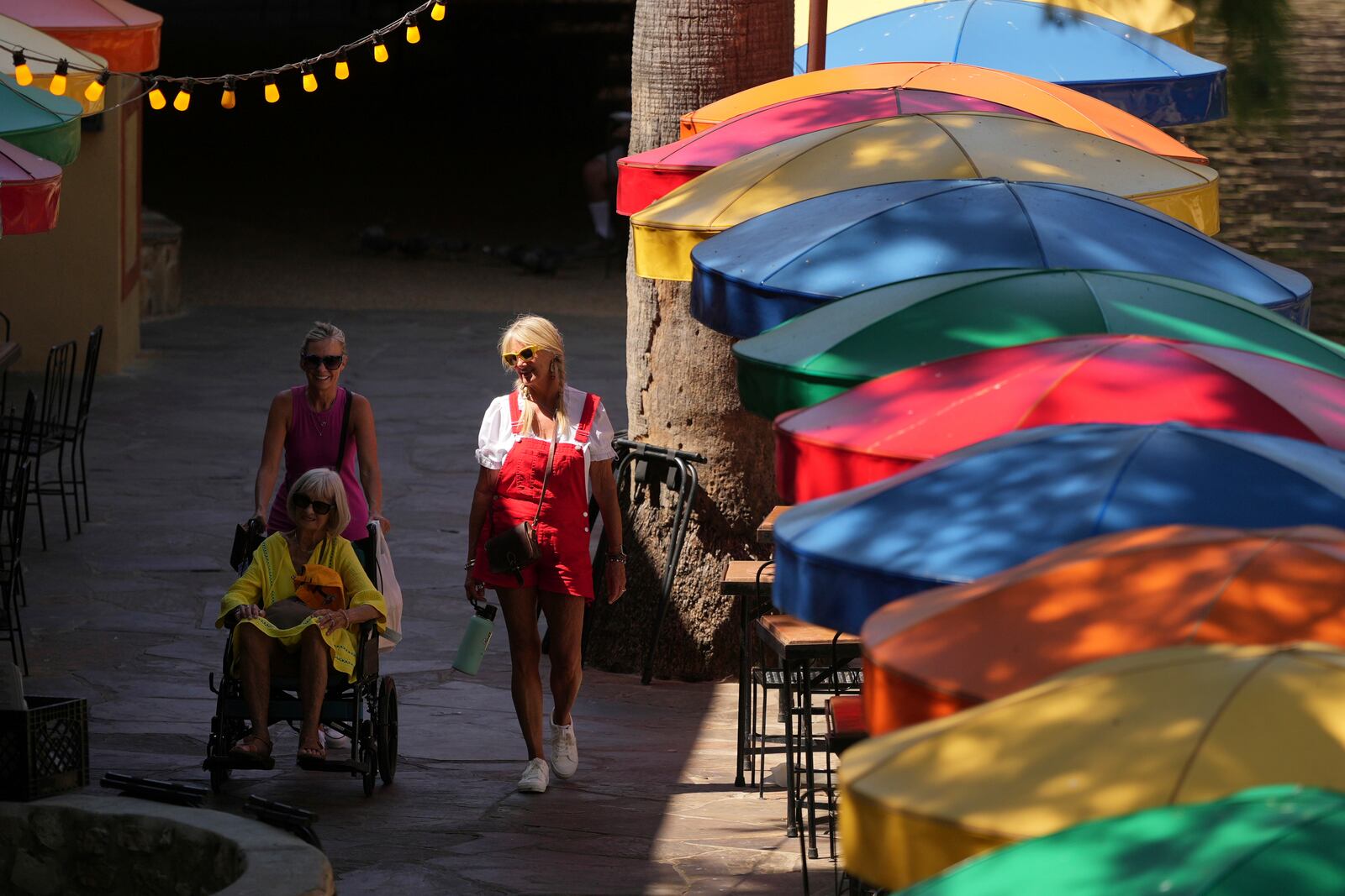 Visitors walk along the River Walk as temperatures top the triple-digit mark, Tuesday, May 13, 2025, in San Antonio. (AP Photo/Eric Gay)