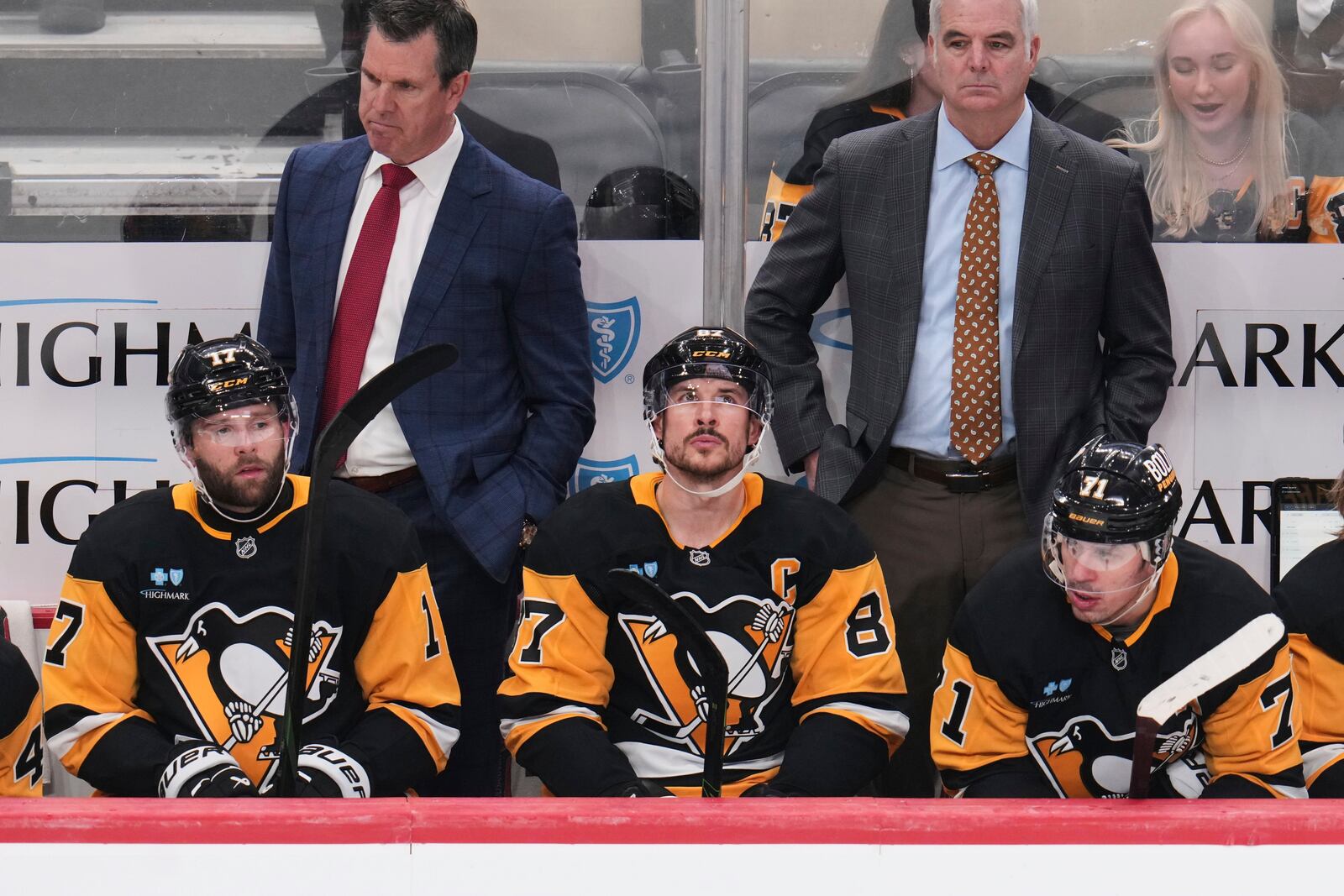 Pittsburgh Penguins' Bryan Rust (17), Sidney Crosby (87), and Evgeni Malkin (71) sit on the bench in front of head coach Mike Sullivan, left rear, and assistant coach Mike Vellucci during the third period of an NHL hockey game against the Boston Bruins in Pittsburgh, Sunday, April 13, 2025. (AP Photo/Gene J. Puskar)