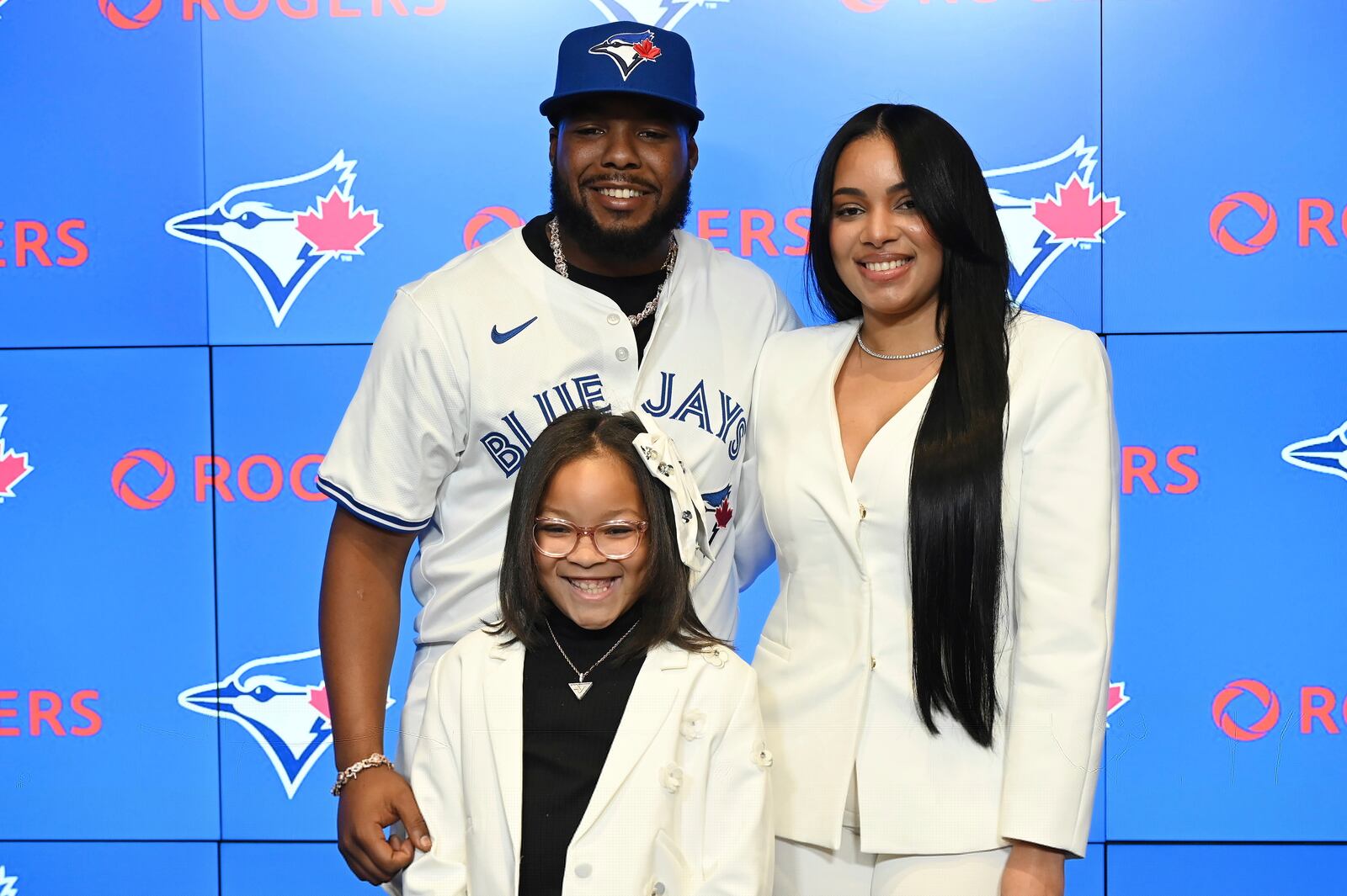 Toronto Blue Jays first baseman Vladimir Guerrero Jr., left, poses with wife Nathalie and daughter Vlaimel pose together following a press conference announcing Guerrero's 14 year, $500 million dollar contract extension in Toronto on Monday April 14, 2025. (Jon Blacker/The Canadian Press via AP)