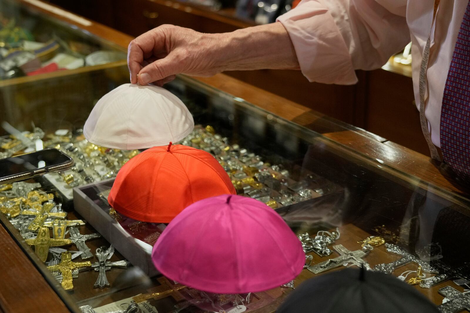 Italian tailor Raniero Mancinelli, who on his own initiative is making outfits for a possible future Pope, shows a pontiff's skull cap as he is interviewed by the Associated Press inside his shop, in Rome, Wednesday, April 30, 2025. (AP Photo/Gregorio Borgia)