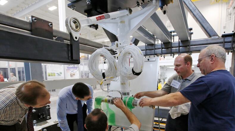 Engineers and visitors at the new University of Dayton Research Institute Structures & Materials Assessment, Research and Test (SMART) Laboratory discuss the sensors used to test the landing gear of a Lockheed C-130 Hercules cargo plane in this 2020 file photo.