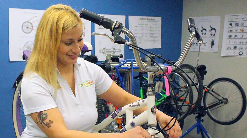 Rene Stratton with Springfield City Schools looks over some of the bikes that are part of the Earn-A-Bike Program. JEFF GUERINI/STAFF