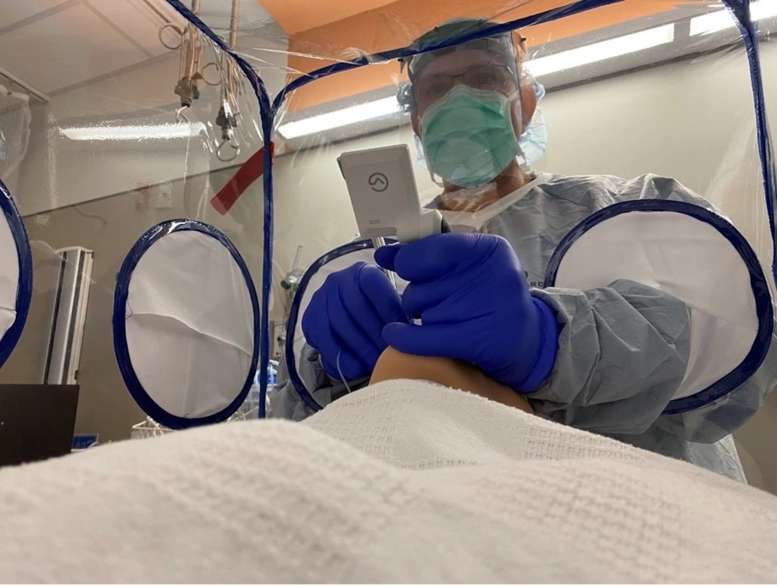 The Small Business Innovation Research program funded the development of an enclosure (seen in this 2021 Air Force photo) that allowed medical staff to work with patients while significantly reducing droplets during the COVID-19 pandemic. Air Force Research Laboratory photo by Marcus Morton