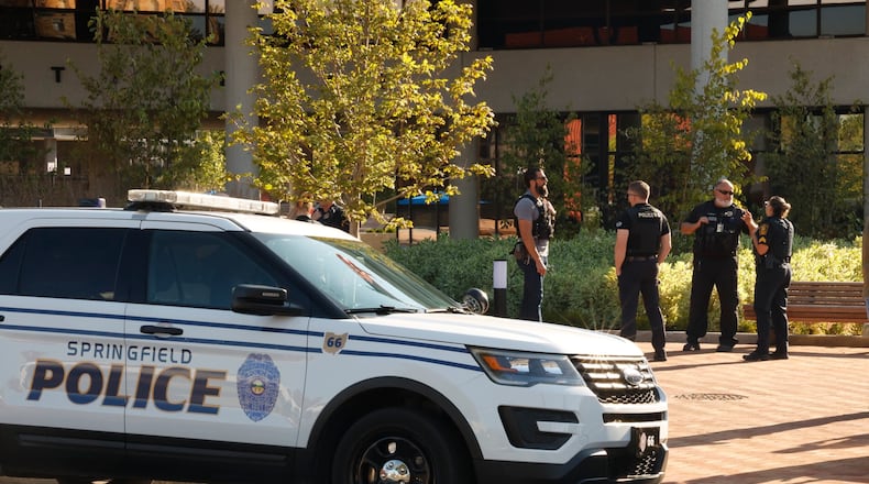 Springfield and Dayton police officers outside the City Hall building following an evacuation due to a threat Thursday. BILL LACKEY/STAFF