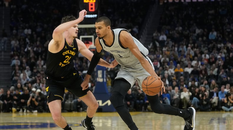 San Antonio Spurs center Victor Wembanyama, right, drives to the basket against Golden State Warriors center Quinten Post during the first half of an NBA basketball game in San Francisco, Wednesday, Feb. 11, 2026. (AP Photo/Jeff Chiu)